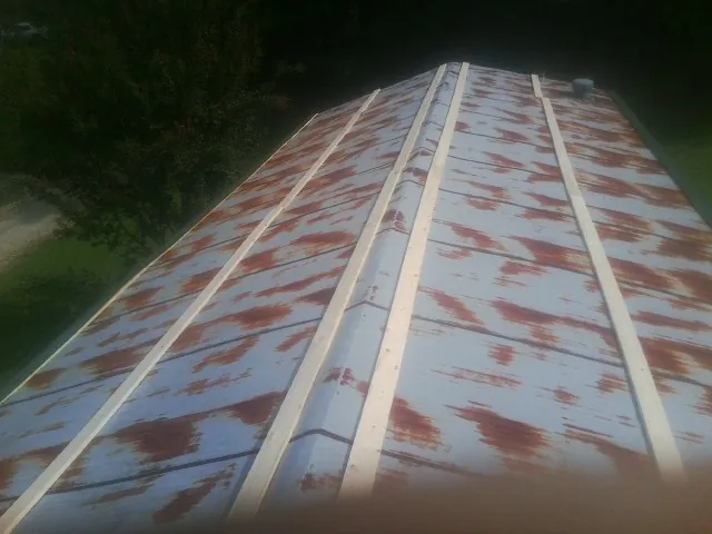 Rusted metal roof panels with new wood purlins before replacement — Storm Damage Roof Repair in Cordele by Roofing Brothers